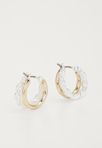 Orecchini a cerchio in oro e argento con un design attorcigliato. Finitura in metallo liscia con una qualità riflettente e un gancio sicuro.