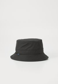 Chapeau de seau noir en tissu doux, doté d'un large bord, de coutures horizontales et d'un petit logo bleu sur le côté.