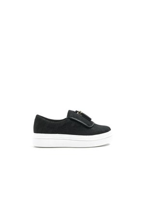 Sort slip-on sneaker med tyk hvid sål og dekorativ lynlåsdetaile øverst mod hvid baggrund.