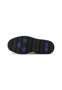 Suela de zapato de goma negra con ranuras horizontales, que presenta una sección azul oscura con manchas blancas. Diseño robusto con estrías texturizadas.