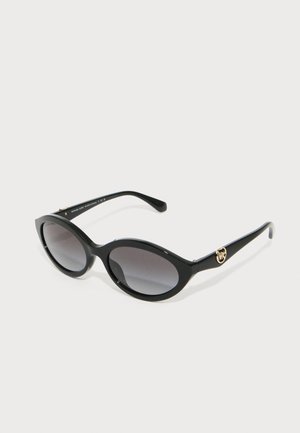 Sorte katteøye solbriller med grå gradientlinser. Har blanke plastinnfatninger og gullfargede logo akcent på baugen.