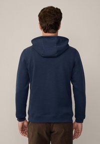 Marineblauwe hoodie van zacht materiaal, met een voorzak en ribgebreide manchetten. Het ontwerp bevat een royale capuchon en een ontspannen pasvorm.
