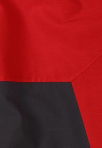 Tissu rouge et noir, avec une texture lisse. Présente une couture diagonale nette là où les couleurs se rencontrent, créant un élément de design géométrique.