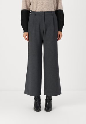 Wide-leg grey trousers made of textured fabric, featuring a high waist and front pleats, paired with black ankle boots.
