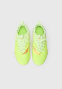 Neon żółte buty piłkarskie z teksturowaną cholewką, z zapięciem na sznurówki i pomarańczowymi akcentami. Posiadają miękką siateczkową podszewkę oraz pętelkę do zakładania.