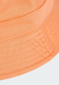 Orange bucket hat with a textured fabric, featuring horizontal ribbed patterns and a stitched brim.