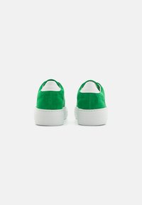 Green suede sneakers with a white rubber sole, featuring a smooth leather back tab and padded collar for comfort.