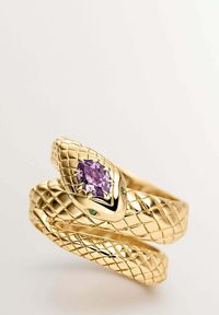 Anillo de oro en forma de serpiente con un patrón tejido texturizado, que presenta una gema púrpura central y dos acentos verdes.