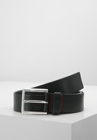 Cintura in pelle nera con una fibbia in metallo argento e dettagli di cucitura rossa. La fascia è liscia e piatta, con una forma rettangolare classica.