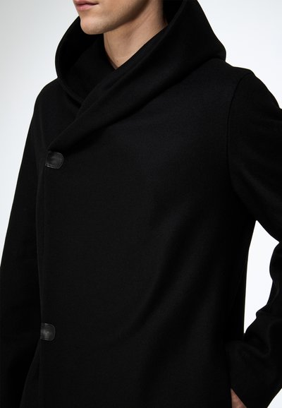 Schwarzer Wollmantel mit großer, drapierter Kapuze und einem sichtbaren Knopf. Glatte Textur und klare Linien, die ein minimalistisches Design betonen.