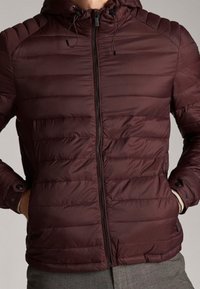 Bordeaux polstret jakke med lynlås foran, quiltet design, justerbar hætte med snoretræk og knapdetaljer på ærmerne.