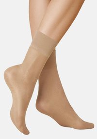 Beige sheer ankle socks with a smooth, glossy finish. Elastic band at the top provides secure fit, enhancing comfort and wearability.