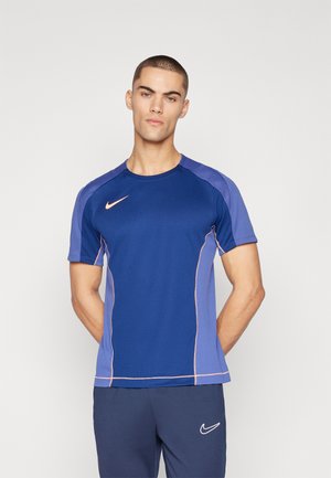 Nike blue athletic t-shirt with short sleeves, featuring mesh texture, orange accents, and a logo on the chest and shoulder.