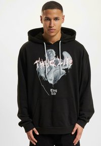 Sudadera negra de algodón con una gran impresión gráfica que presenta una figura gris y el texto rojo "Thug Life". Incluye un bolsillo delantero y cordones.