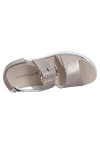 Light metallic beige sandal with two wide straps, adjustable buckle, and white rubber sole. Smooth texture and cushioned footbed visible.