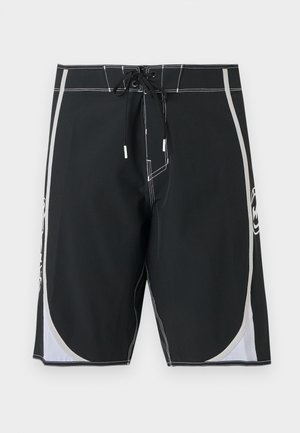 Svarte badeshorts til knelengde med hvite sidepaneler, hvit søm og snøring foran.