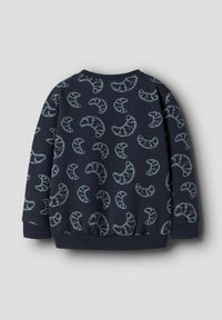 Granatowa bluza z wzorem jasnych półksiężyców, z prążkowanymi mankietami i dołem, wykonana z miękkiego, fakturowanego materiału.