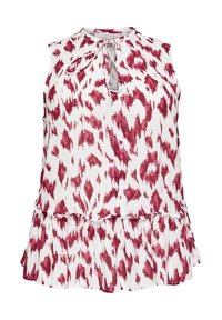 Ärmlös blus i vitt tyg med ett rött abstrakt mönster, med en nyckelhålsringning och en utfläkt, lager-på-lager nederdel.