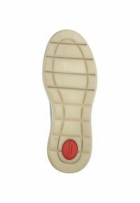 Sola di una scarpa con una suola in gomma beige, caratterizzata da scanalature orizzontali e un accento circolare rosso sul tallone con un marchio.