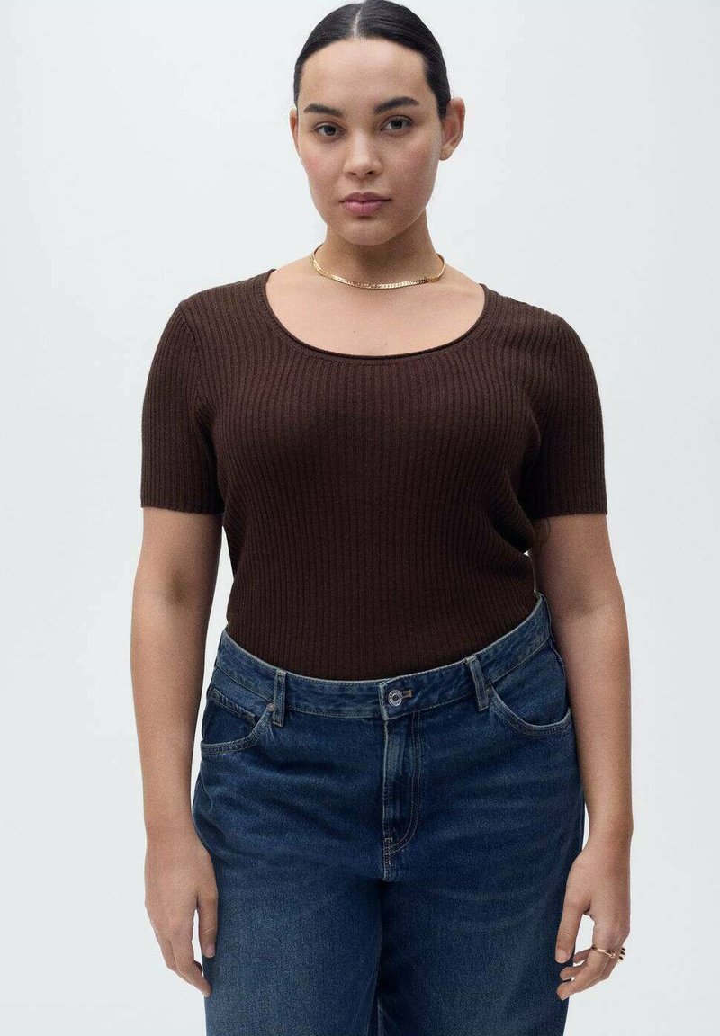 Top marrone a maniche corte con costine e scollo ampio, abbinato a jeans high-waisted blu scuro. Design semplice e silhouette aderente.