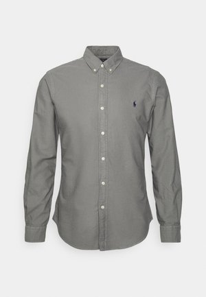 Chemise grise pour homme à manches longues, boutonnée sur le devant, avec col boutonné et petit logo brodé sur le côté gauche de la poitrine.