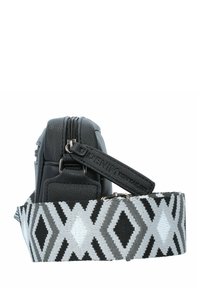 Schwarze Kunstledertasche mit strukturierter Oberfläche, ausgestattet mit einem oberen Reißverschluss. Verstellbarer Gurt mit einem geometrischen Schwarz-Grau-Muster.