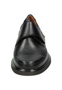 Zwarte leren schoen met een ronde neus, klittenbandsluiting en een laag profiel rubberen zool. Gladde textuur zonder extra patronen.