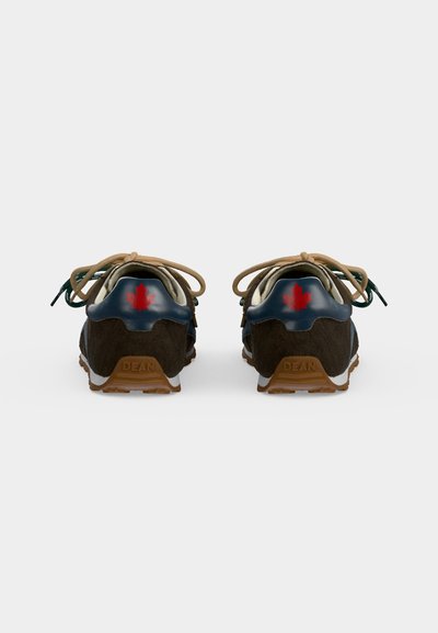 Paire de baskets marron et bleu marine avec des lacets beige, montrant un détail de feuille d'érable rouge sur la languette de talon bleu marine et "DEAN" embossé sur la semelle marron.