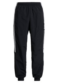 Svarta träningbyxor med elastisk midja, avsmalnande muddar och vita sidostrick. Tillverkade av ett mjukt, lätt tyg med en avslappnad passform.