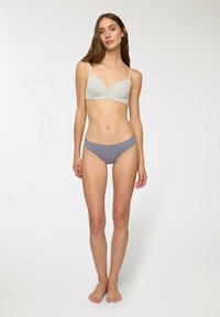 Reggiseno grigio senza cuciture con scollatura profonda e spalline regolabili, abbinato a mutandine grigie a vita media, caratterizzate da una texture di tessuto morbido.