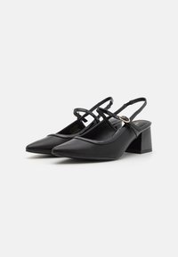 Black slingback shoes with pointed toes, a block heel, and criss-cross straps. Made of smooth synthetic material with a glossy finish.