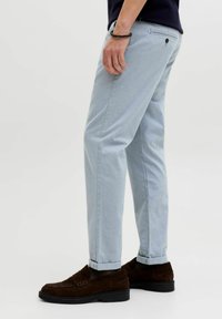 Ανοιχτό μπλε παντελόνι με υφή, ίσια κοπή και γυρισμένα ρεβέρ. Συνδυασμένο με σκούρα καφέ μοκασίνια από σουέντ.