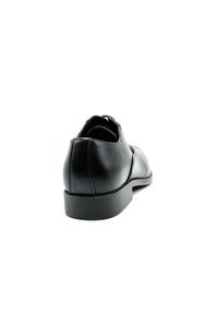 Chaussure de ville en cuir noir avec une finition lisse, un bout arrondi et un petit talon en caoutchouc. Pas d'ornements ou de motifs visibles. Design classique.