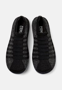 Black and gray textured sneakers with elastic straps, round toe, and a flexible sole. Features a woven upper and a seamless design.