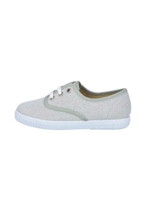 Zapatilla casual de corte bajo de color gris claro con cordones blancos y suela de goma blanca texturizada, vista desde un lateral sobre un fondo blanco.