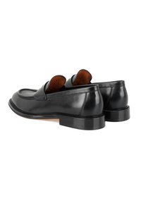 Zwarte leren instappers met een ronde neus, voorzien van een gladde afwerking, dubbele snits aan de bovenkant en een lage geplaatste hak. Binnenvoering van bruine suede.