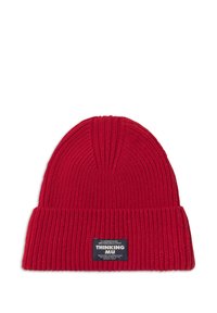 Beanie a coste rossa con bordo piegato e etichetta nera con la scritta "Thinking Mu" su sfondo bianco.