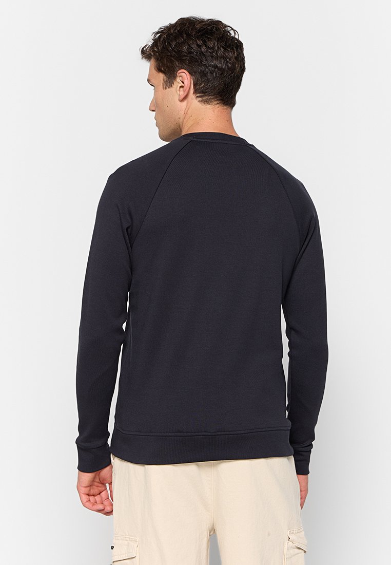 Sweatshirt bleu marine foncé avec un col rond côtelé, des manches raglan longues et un ourlet droit. Fabriqué dans un tissu doux et texturé.