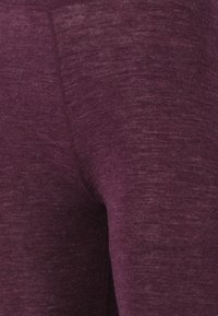 Bordeaux leggings tillverkade av mjukt, strukturerat tyg. Har en slät midja och en figurnära design med minimala sömmar.
