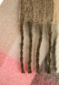 Wielokolorowa filcowa tkanina o miękkiej strukturze; zawiera odcienie brązu, różu i kremu. Zakończona trzema zielonymi, teksturowanymi pasmami zwisającymi z krawędzi.