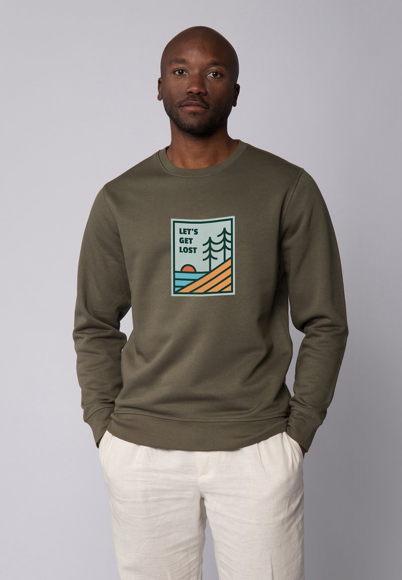 Olivegroen sweatshirt met een ronde hals, voorzien van een gedrukte graphic van bergen, bomen en een zon, aangekleed met blauwe en oranje kleuren.