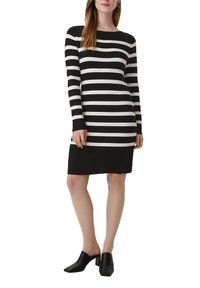 Schwarz-weißer gestreifter Langarmkleid mit taillierter Silhouette, gerippten Bündchen und Rundhalsausschnitt. Kombiniert mit schwarzen Mules.