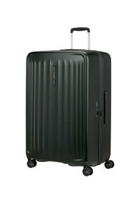 Hard-shell suitcase in dark green with vertical ridges, telescopic handle, four wheels, and built-in lock mechanism. Smooth texture.