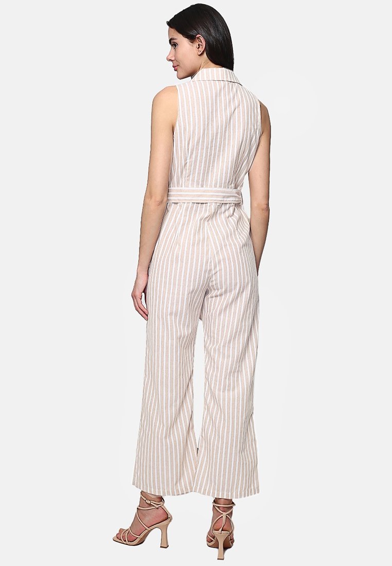 Jumpsuit senza maniche di un leggero beige chiaro con righe bianche verticali, vita con cintura, taglio ampio e collo a camicia, che presenta un tessuto testurizzato.