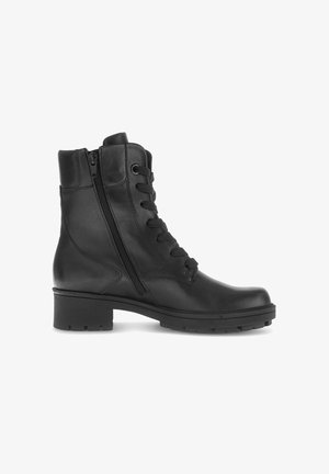 Bottines en cuir noir avec un bout arrondi, une fermeture éclair sur le côté et un laçage à l'avant. Contient des accents texturés et une semelle extérieure robuste pour une meilleure adhérence.