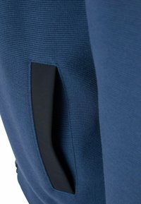 Marineblauwe stof met een gestructureerde afwerking, voorzien van een zwarte zijzak. Het ontwerp is strak en minimalistisch met subtiele details.