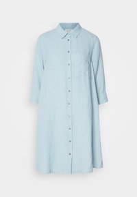 Robe-chemise bleu clair à boutons, manches longues, col et une poche poitrine unique, présentée sur fond blanc.