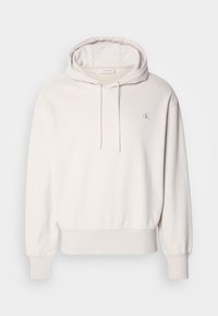 Sweat à capuche Calvin Klein blanc cassé avec poche avant, capuche à cordon, poignets côtelés et petit logo "cK" sur la poitrine.