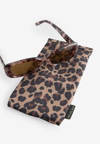 Solbriller med leopardmønster og brune skaldyrs-farvede stel. Leveres med et matchende, tekstureret etui med et sort og brunt mønster.