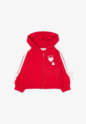 Rode gewatteerde jas met capuchon en ritssluiting, witte strepen op de mouwen, twee witte hartvormige badges op de borst, en gestrikte strikjes bij de manchetten.